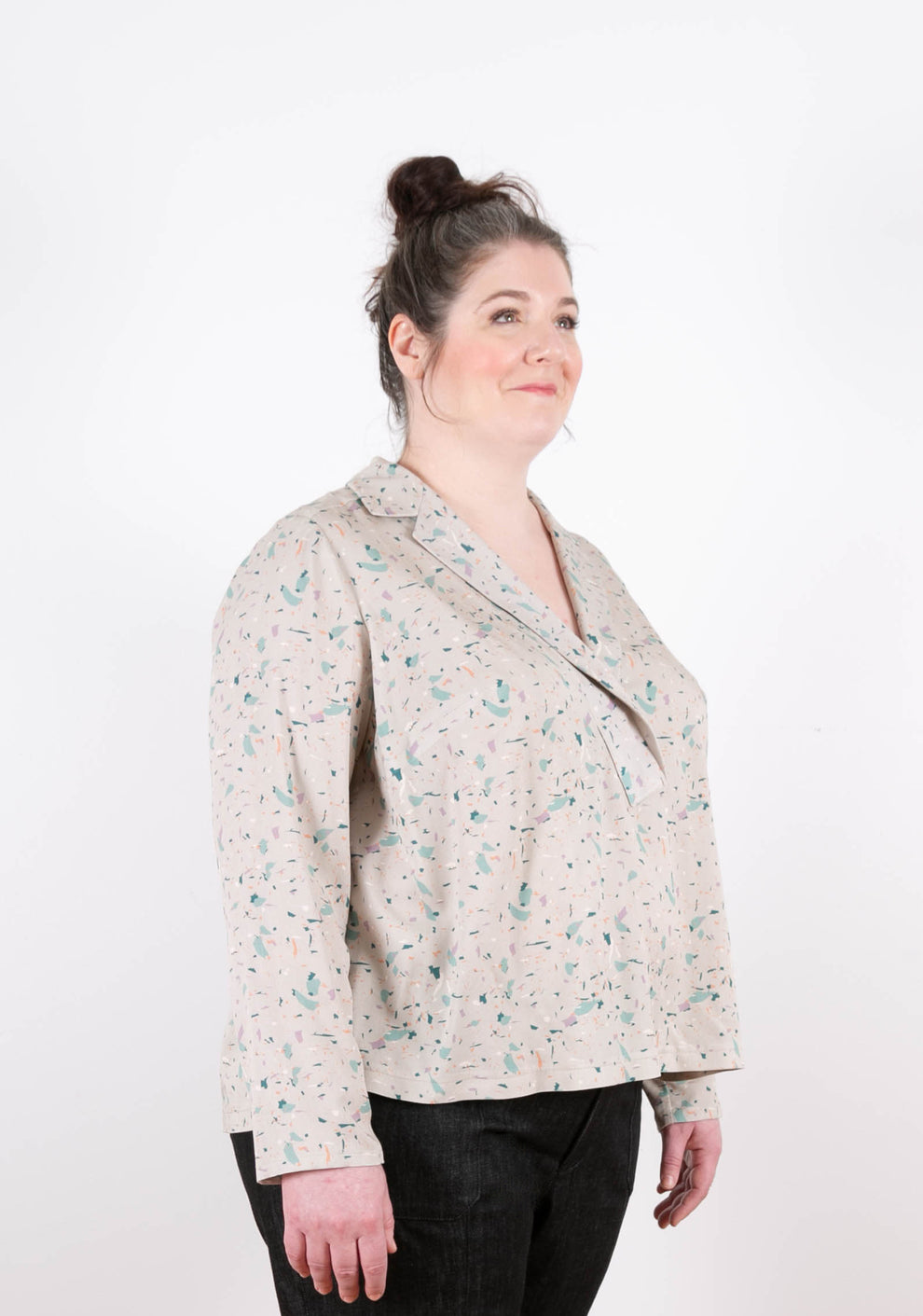 Three-quarter front view of terrazzo print Augusta Top with open V-notch neckline and long sleeves.