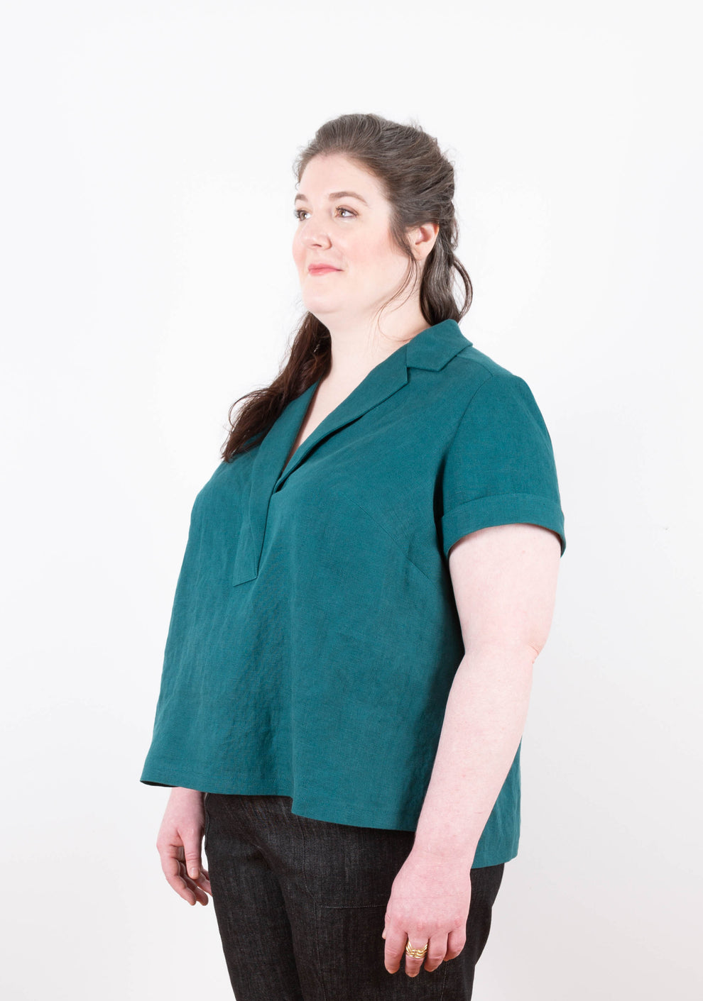 Three-quarter front view of teal linen Augusta Top with short sleeves, relaxed fit, and angled bust dart shaping.