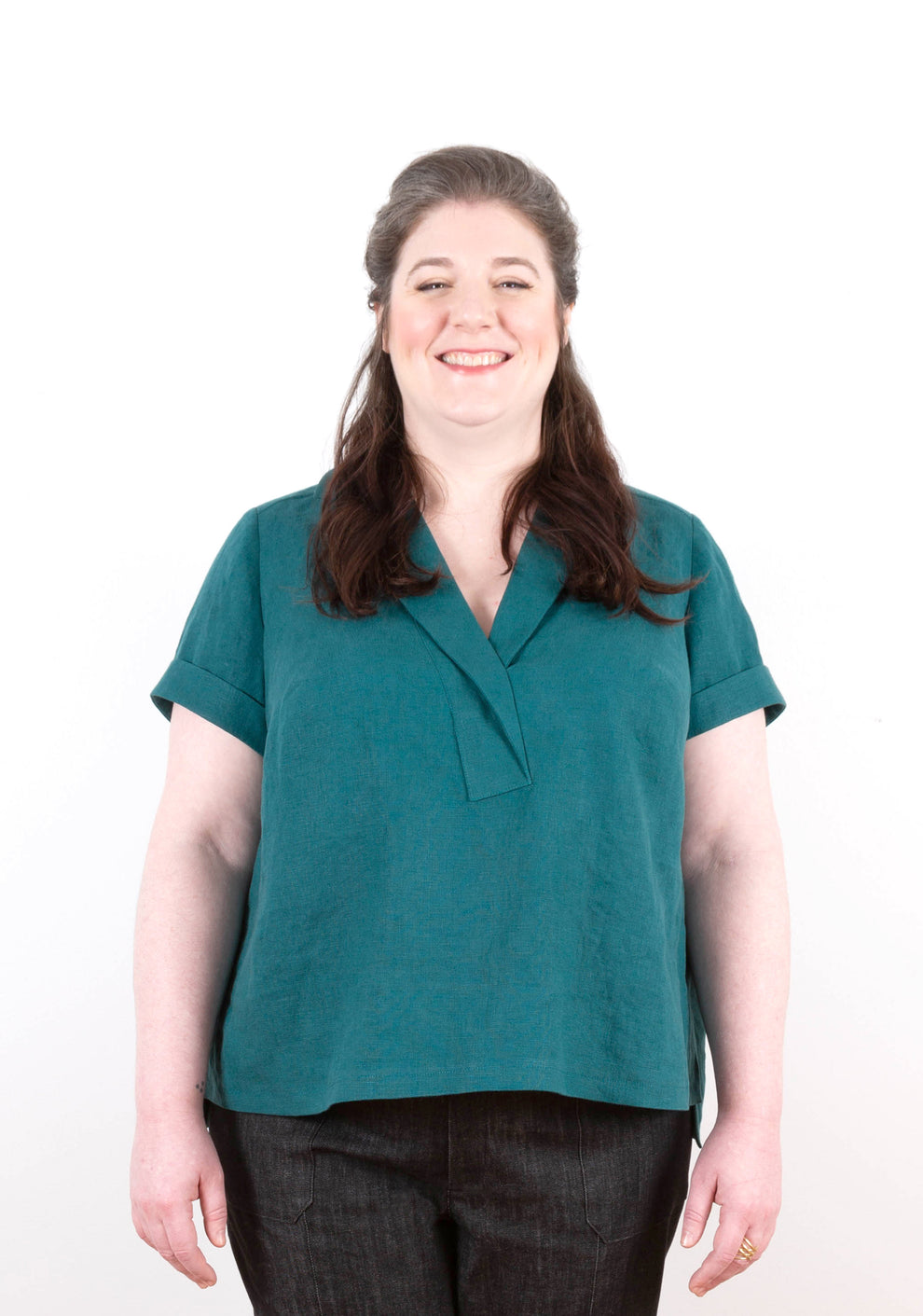 Front view of model wearing teal linen Augusta Top with turned cuff sleeves and split hem.