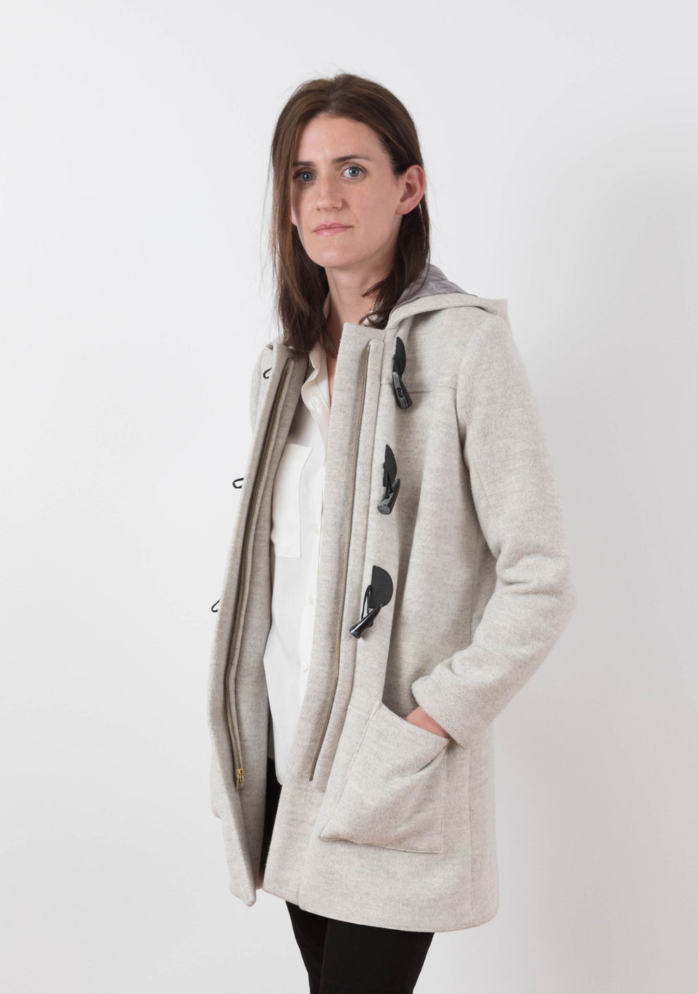 Front view of long Cascade Duffle Coat in heathered gray wool worn open to show zipper closure underneath toggles.