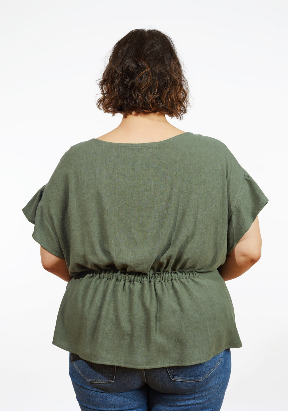 Back view of Corin Top in olive linen showing gathered waist and dropped shoulder flounce sleeves on model.