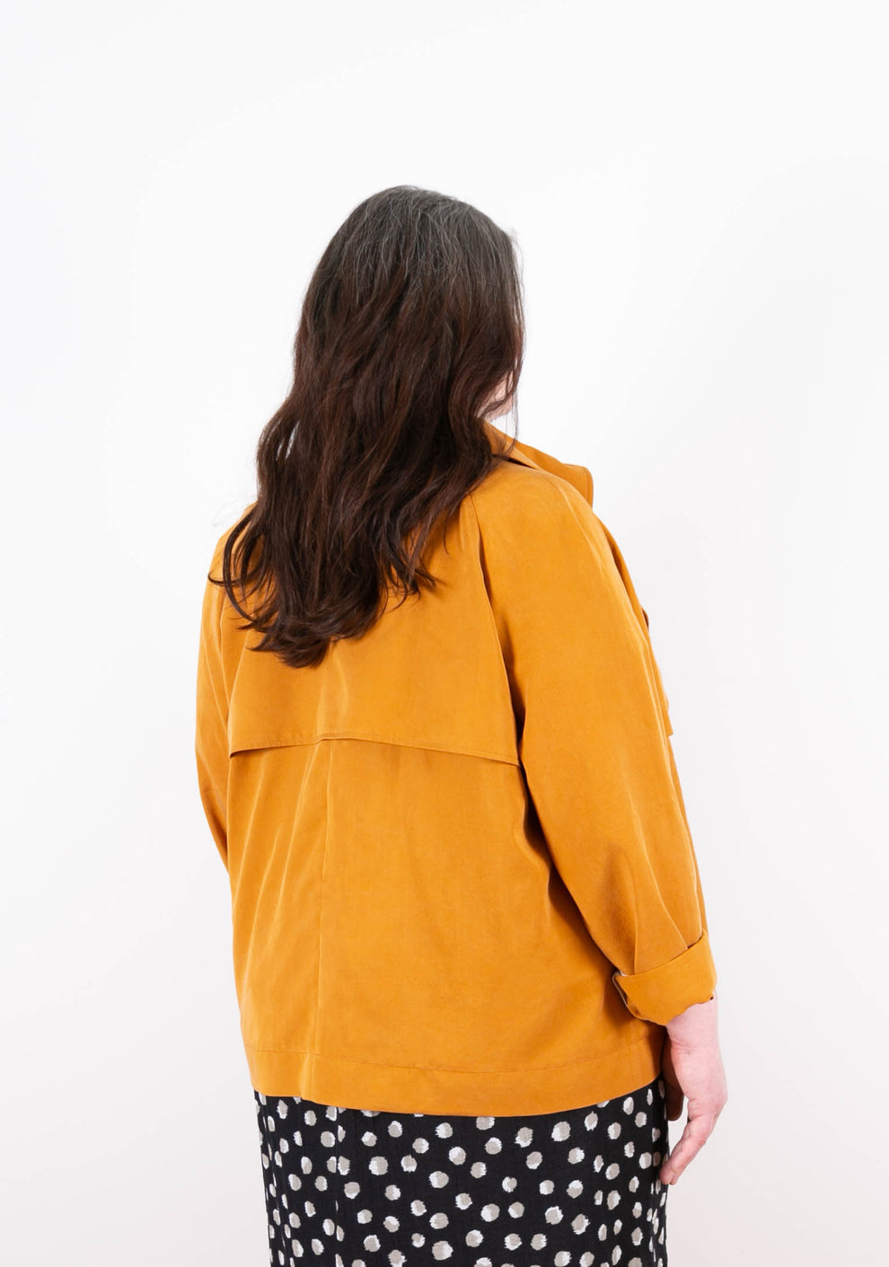 Back view of golden Cortland Trench showing back yoke and pleat detail.