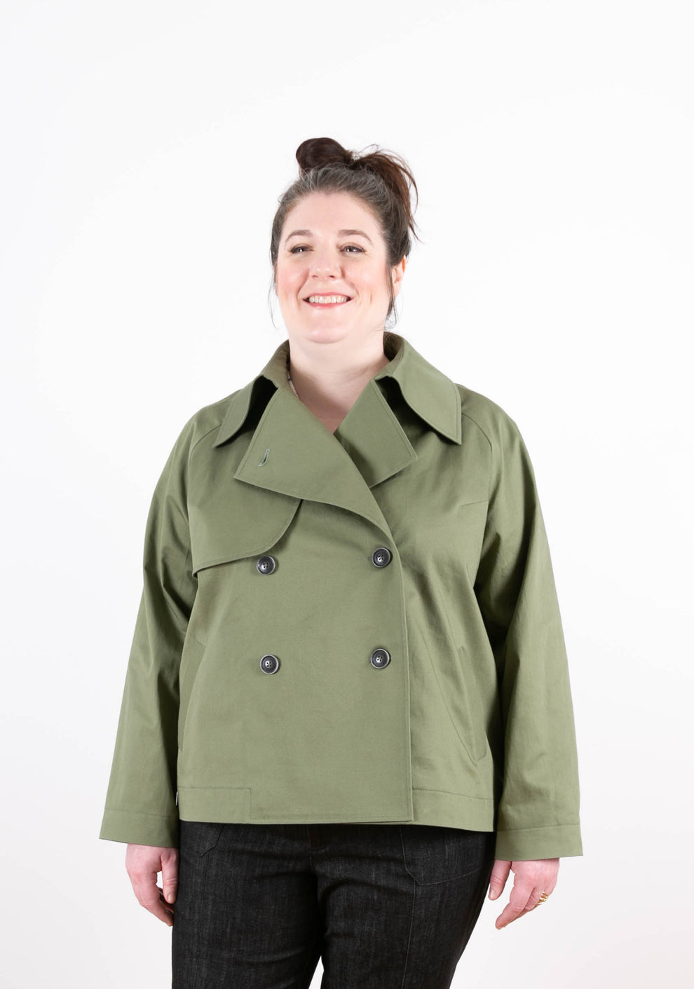Model wearing green Cortland Trench buttoned at front, shown from the waist up.