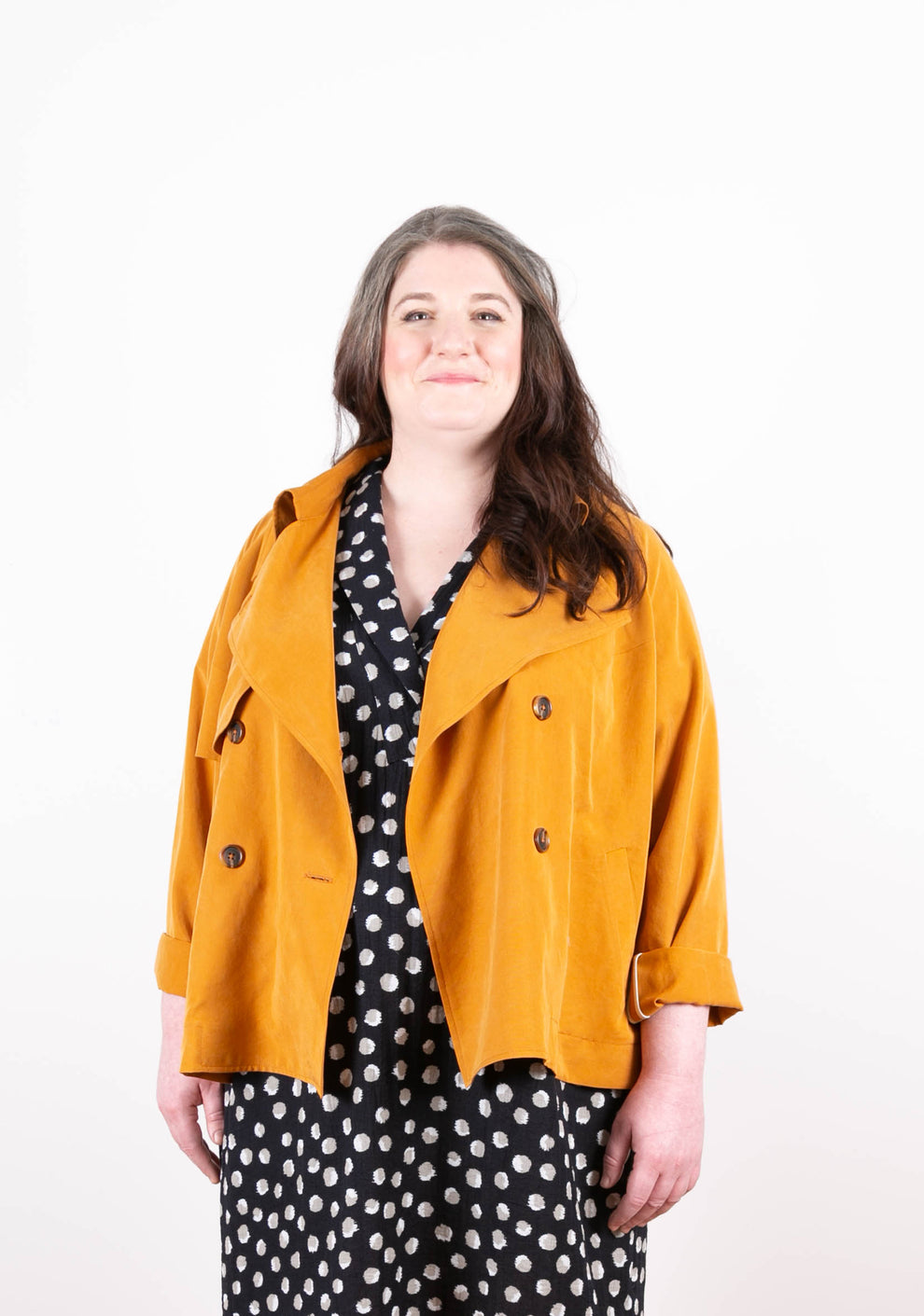 Model: Size 20, 5'5" | Model in golden Cortland Trench with sleeves rolled, over a polka dot dress.