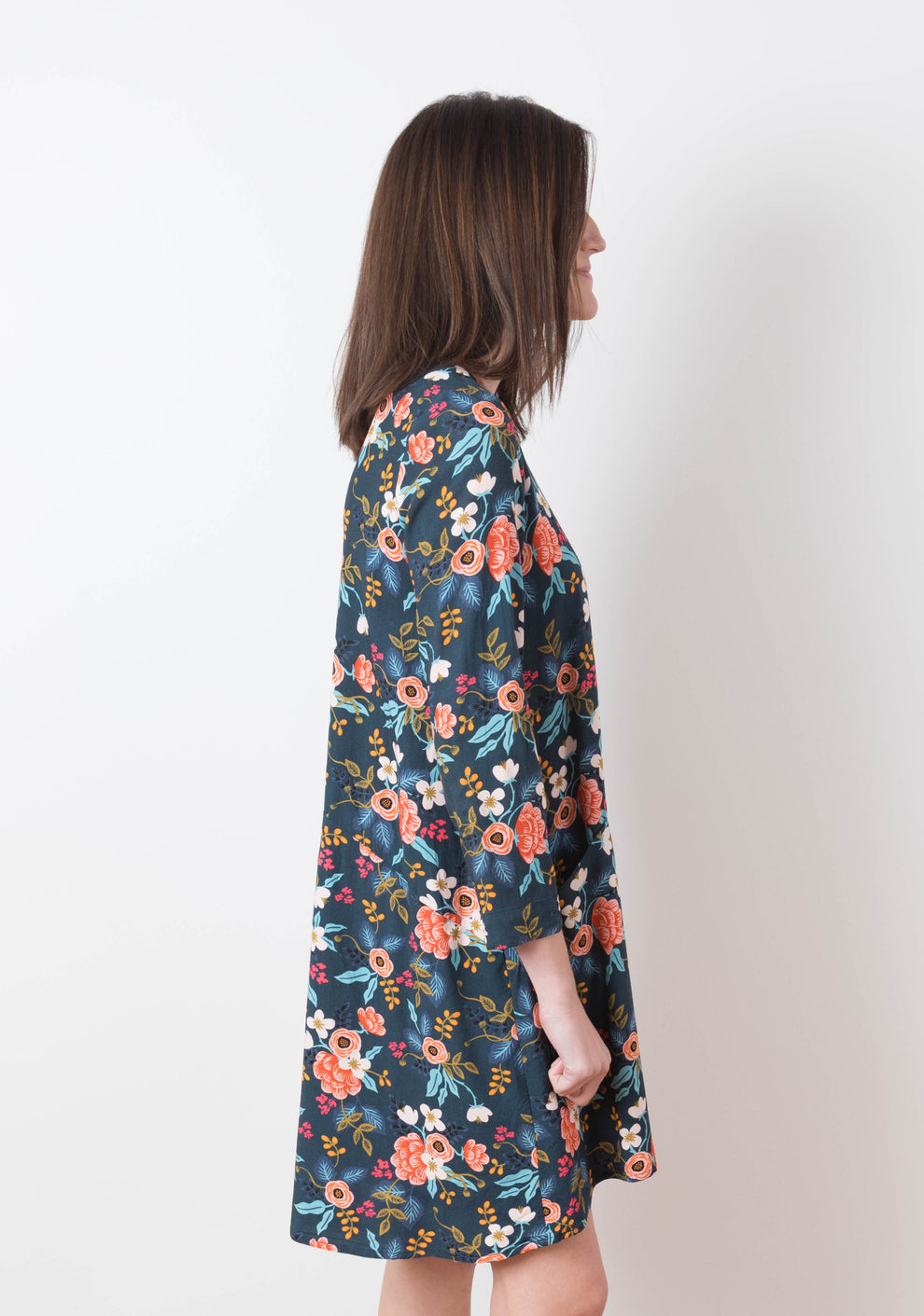 Side view of model wearing floral Farrow Dress with long sleeves and front pockets, view B.