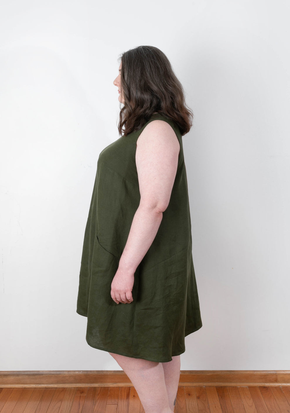 Side view of sleeveless Farrow Dress in olive linen showing angled side seam and A-line silhouette.