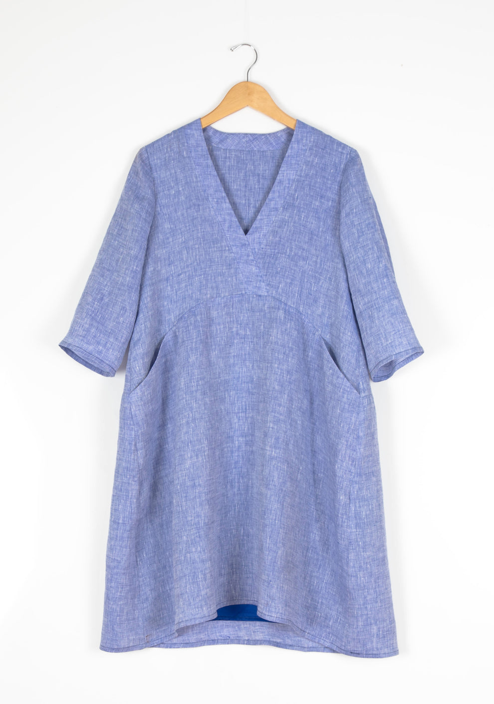 Flatlay of Felix Dress in blue linen fabric,3/4 sleeves shown.