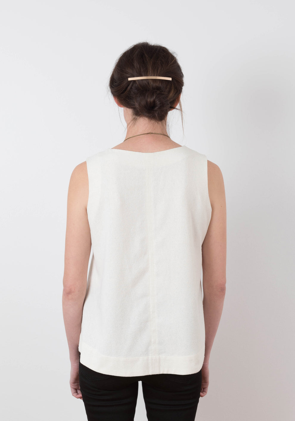 Back view of sleeveless Hadley Top in white showing simple V-back seam, worn by model.