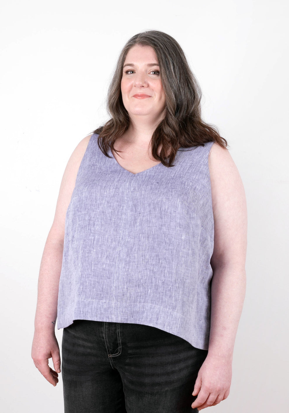 Model wearing sleeveless lilac Hadley Top, slight angle. Garment has a soft drape and V neckline.