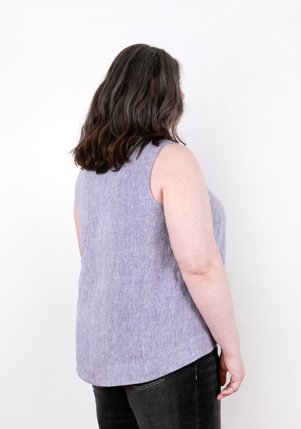 Back view of model wearing sleeveless lilac Hadley Top, showing center back seam and hem shape.
