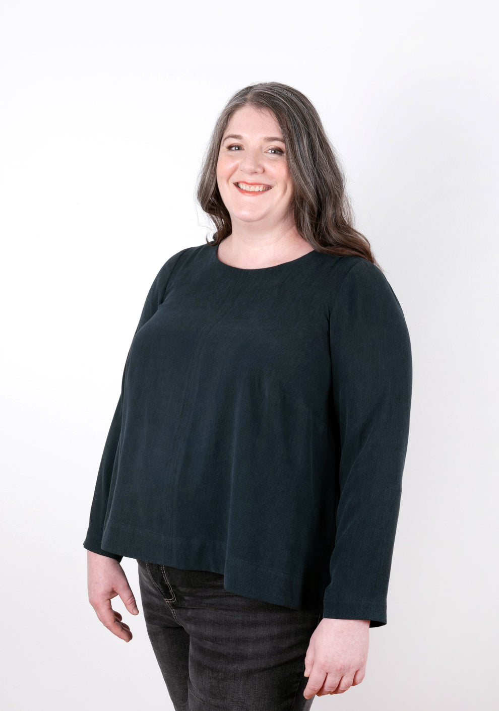 Model wearing dark long-sleeve Hadley Top, front view. Garment features a swing shape and jewel neckline.