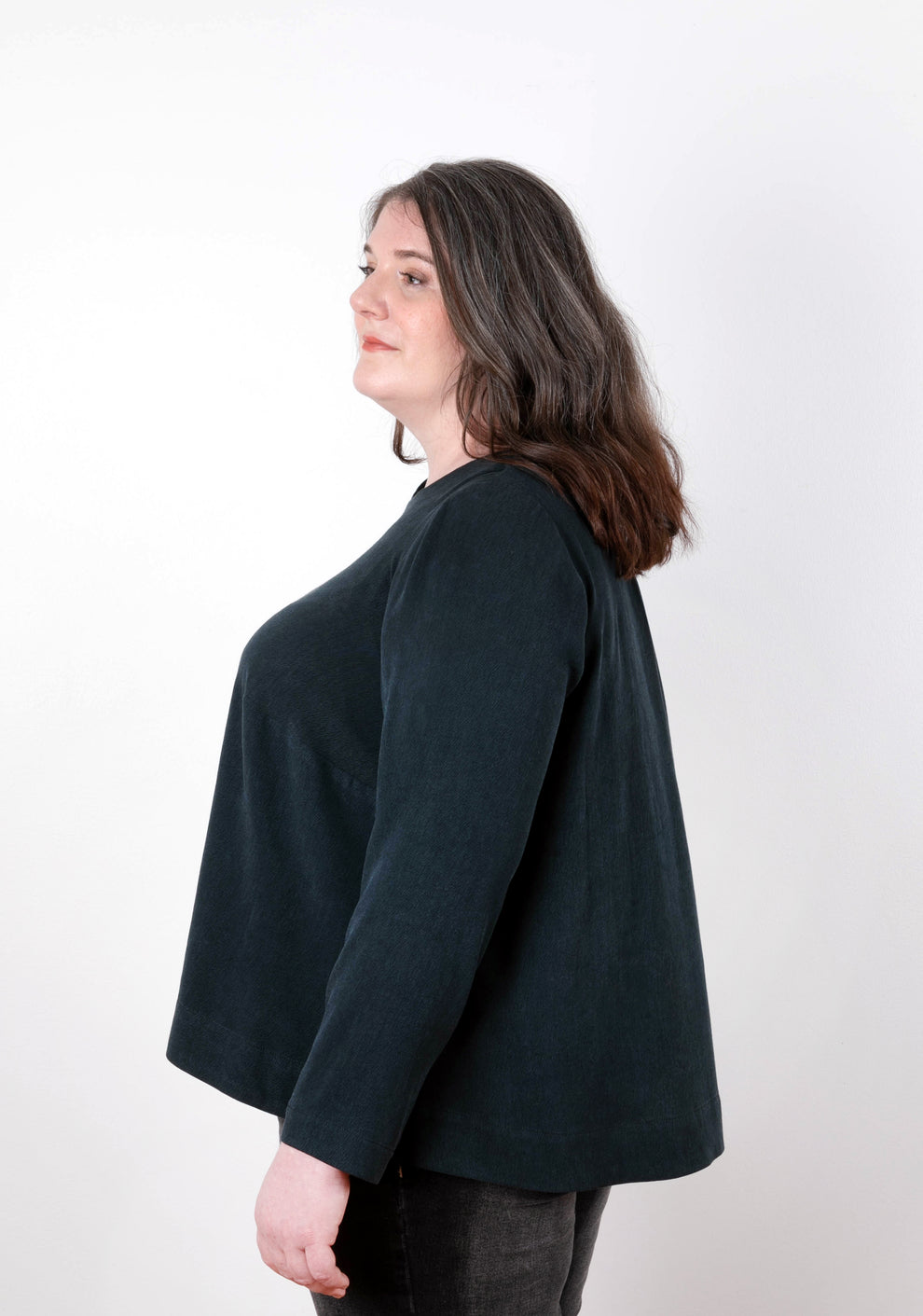 Side view of model in dark long-sleeve Hadley Top, showing A-line silhouette and relaxed fit.