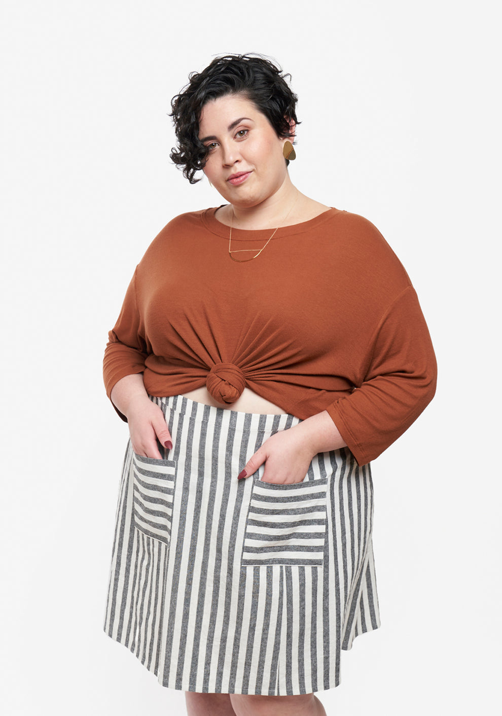 Model wearing cropped Hemlock Tee with long sleeves and striped skirt, shown from front.