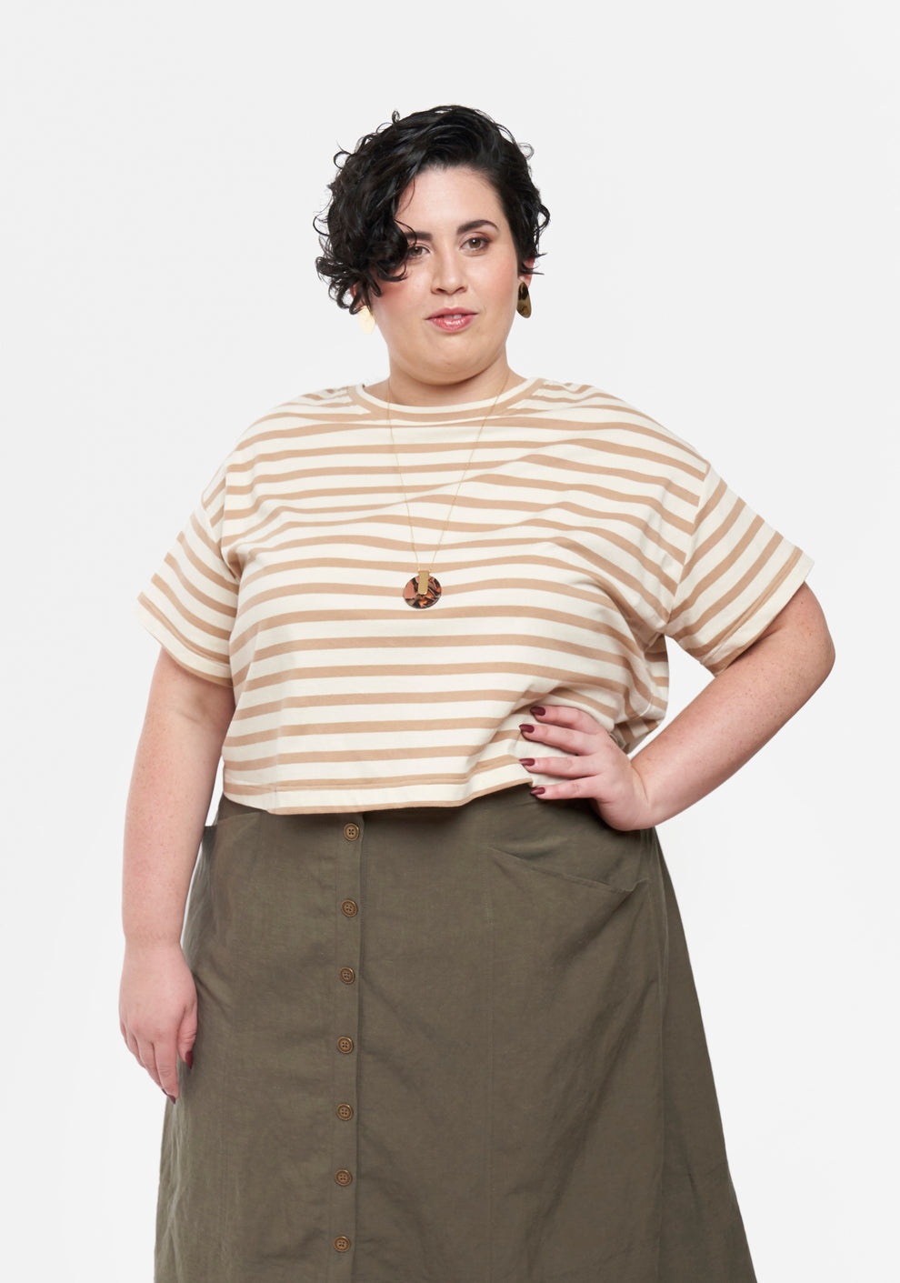 Model wearing cropped Hemlock Tee with short sleeves and beige stripes, tucked into skirt.