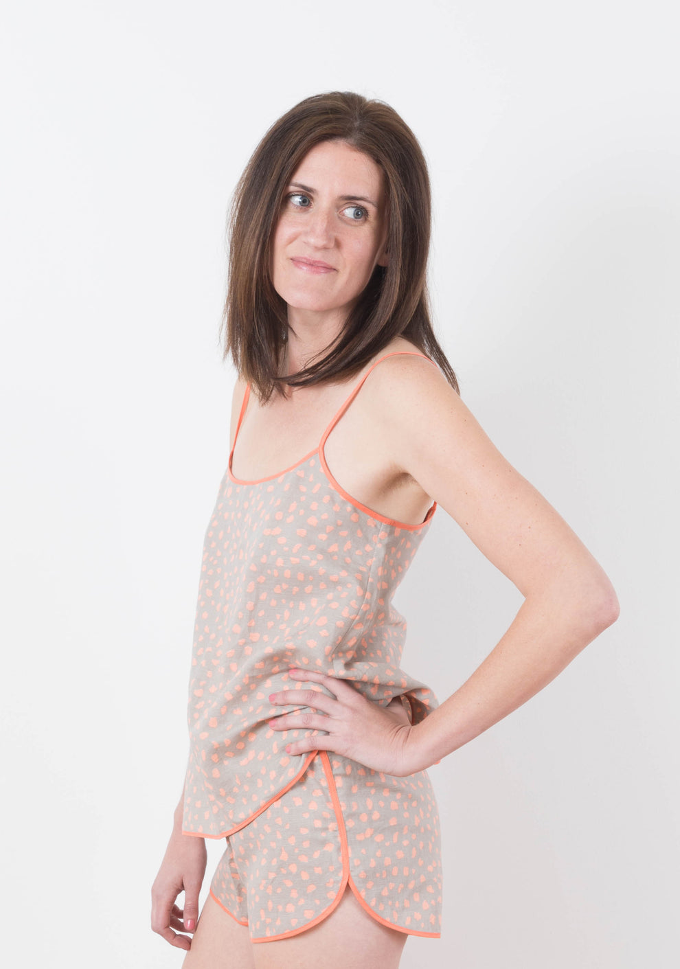 Model: Size 6, 5'8" | Side view of model wearing Lakeside Pajamas in coral dot print with camisole and shorts.