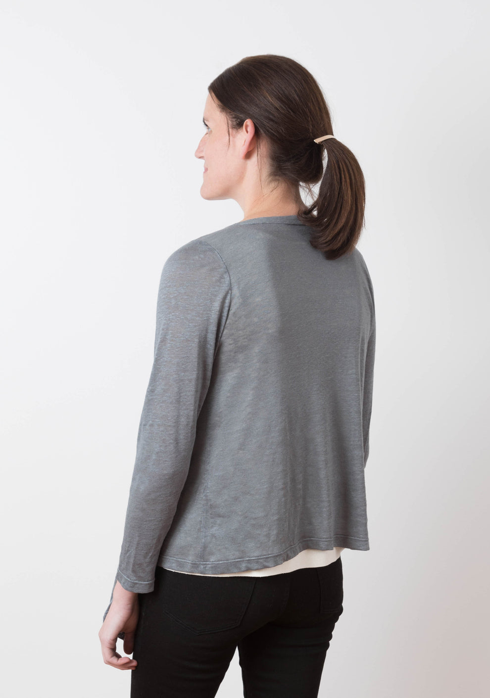 Back view of the grey Lark Cardigan on model showing simple hem and sleeve length.