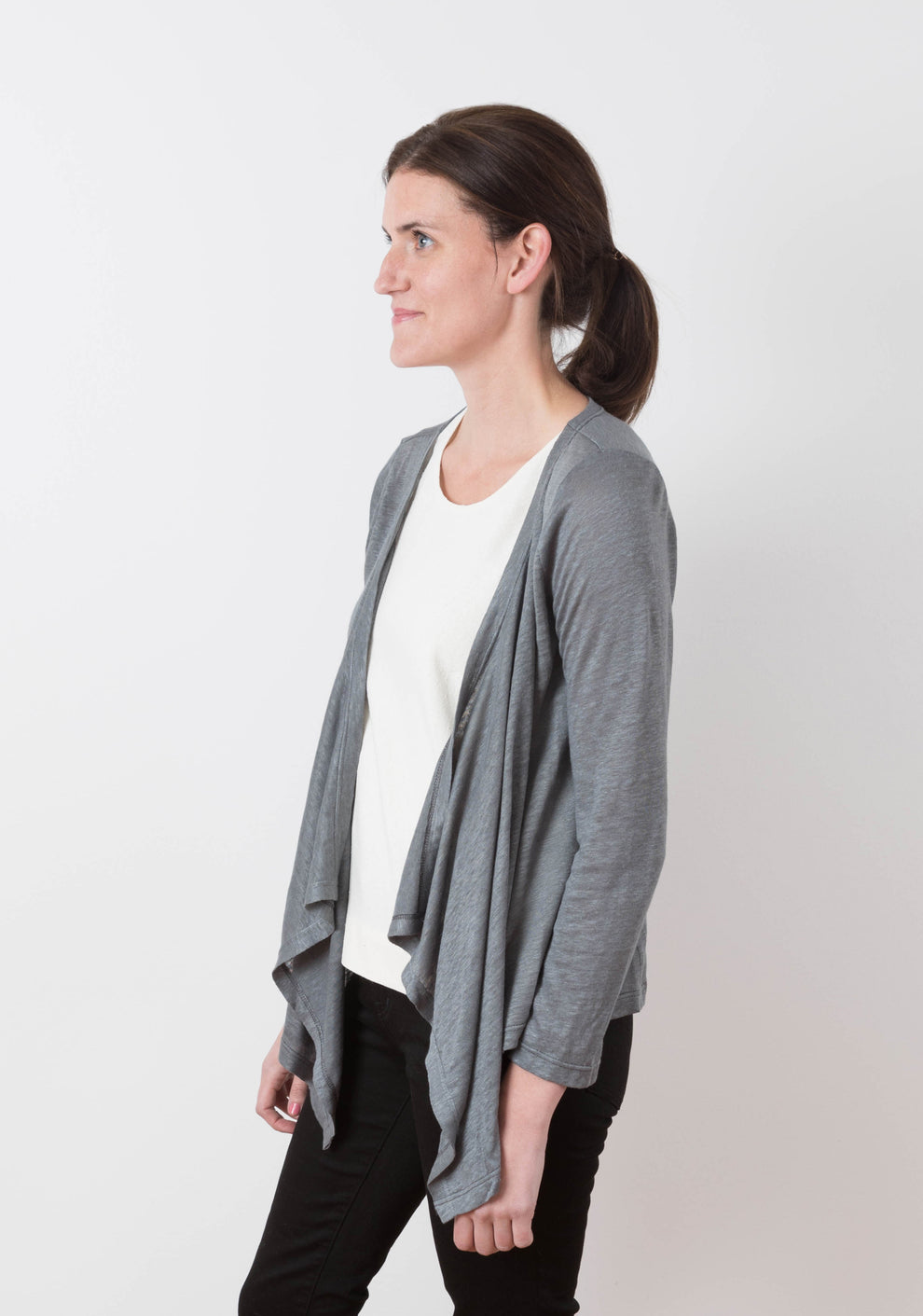 Side view of model wearing the grey Lark Cardigan, highlighting the draped front and sleeve fit.