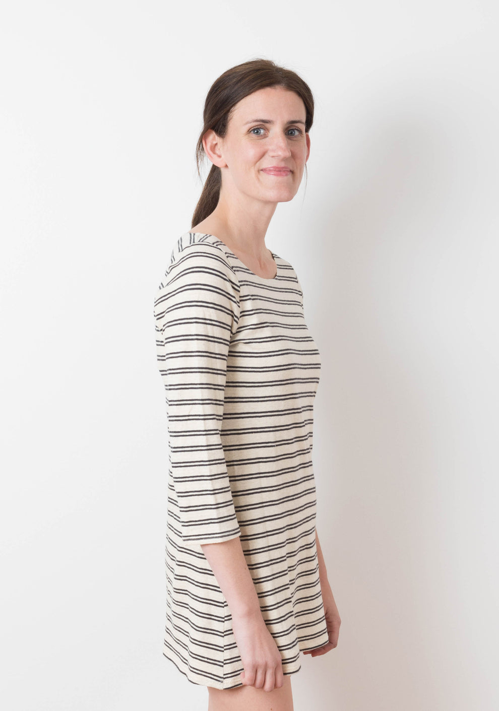 Side view of model in striped mini Lark Dress with scoop neck and 3/4 sleeves.
