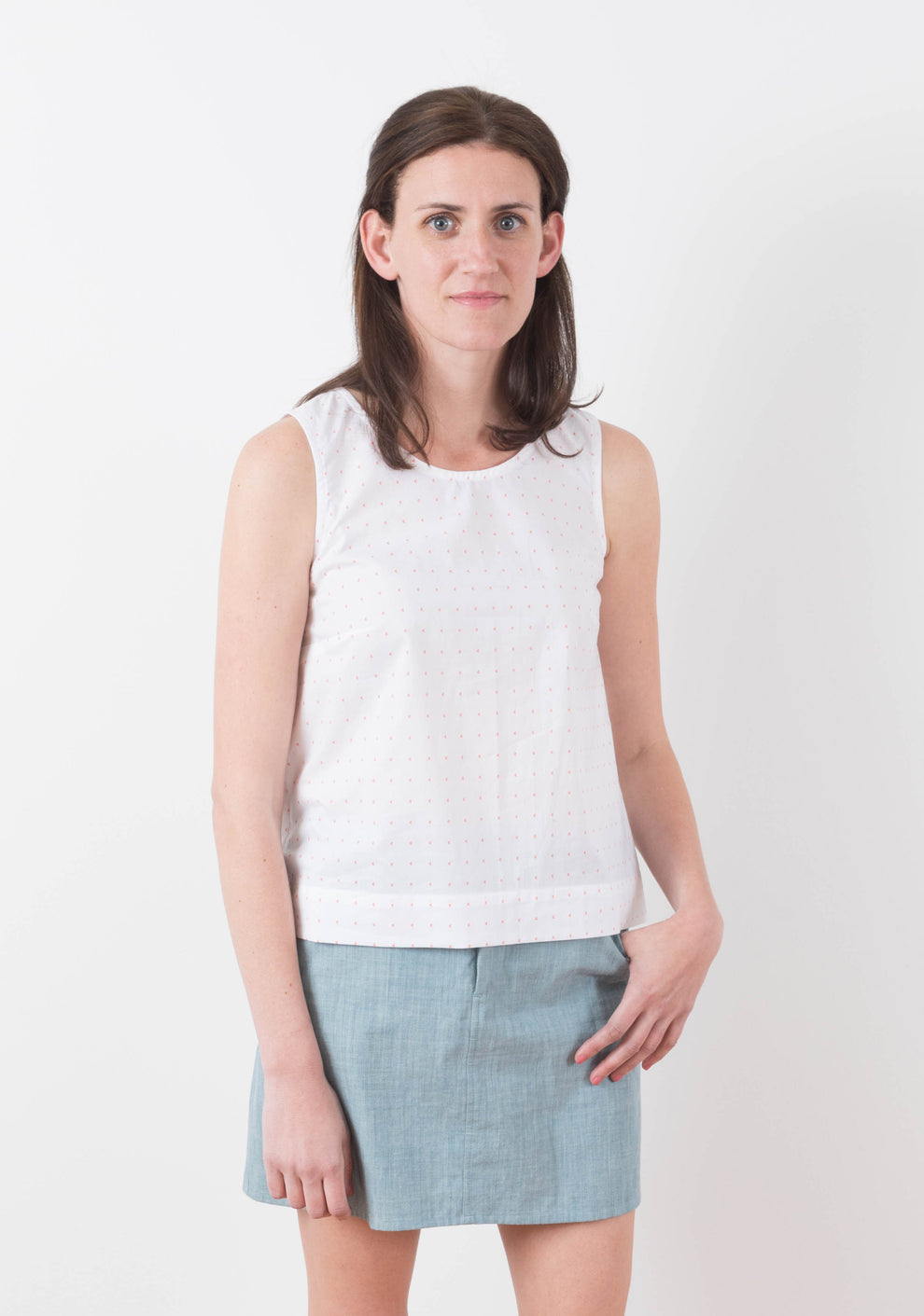Model: Size 6, 5'8" | Front view of Moss Skirt in light blue chambray worn with sleeveless white top.