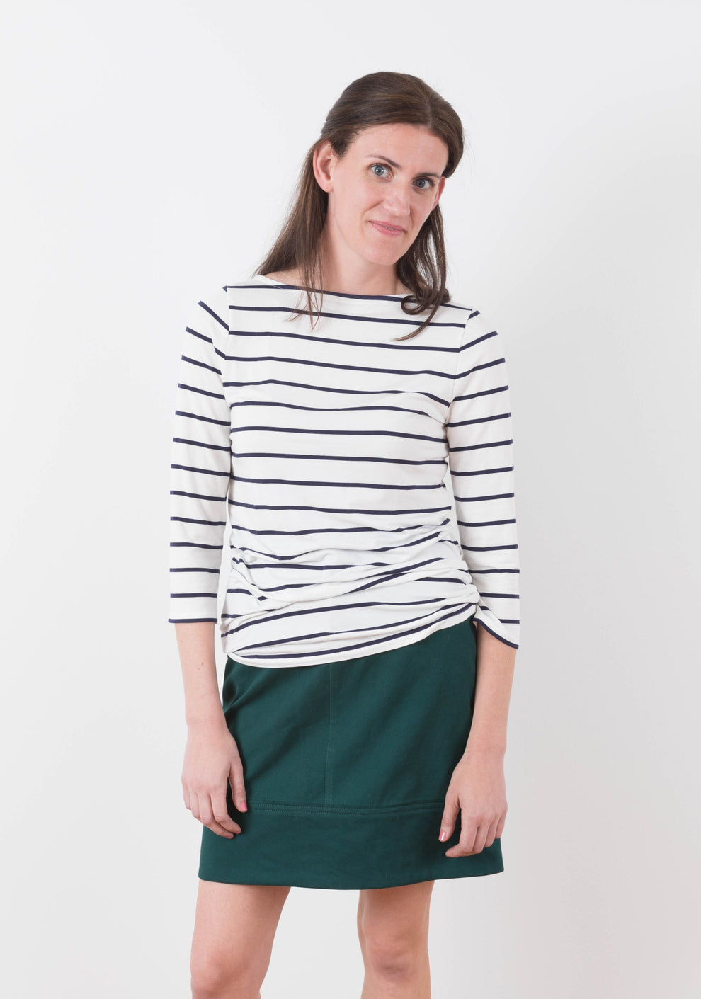 Front view of Moss Skirt in dark green twill paired with striped knit top.