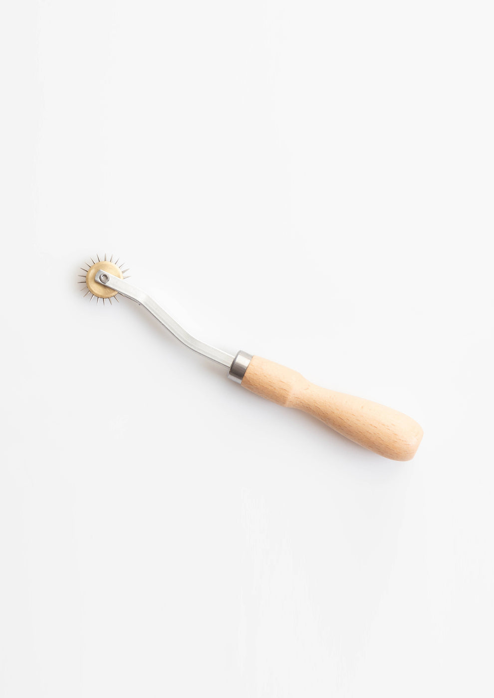 Flatlay of single tracing wheel with wood handle and spiked metal wheel on white background.