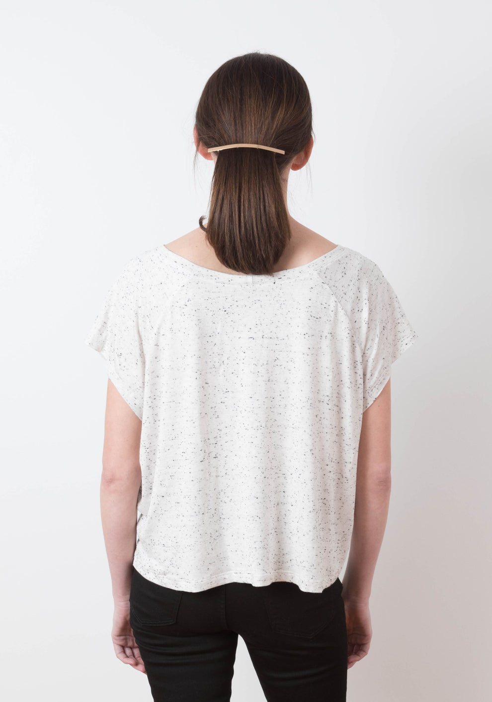 Back view of model in Penny tee highlighting the relaxed fit and soft curved hem of the knit top.