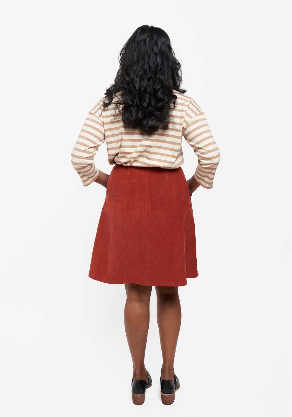 Back view of Reed Skirt in rust corduroy showing waistband and panel seam detail.