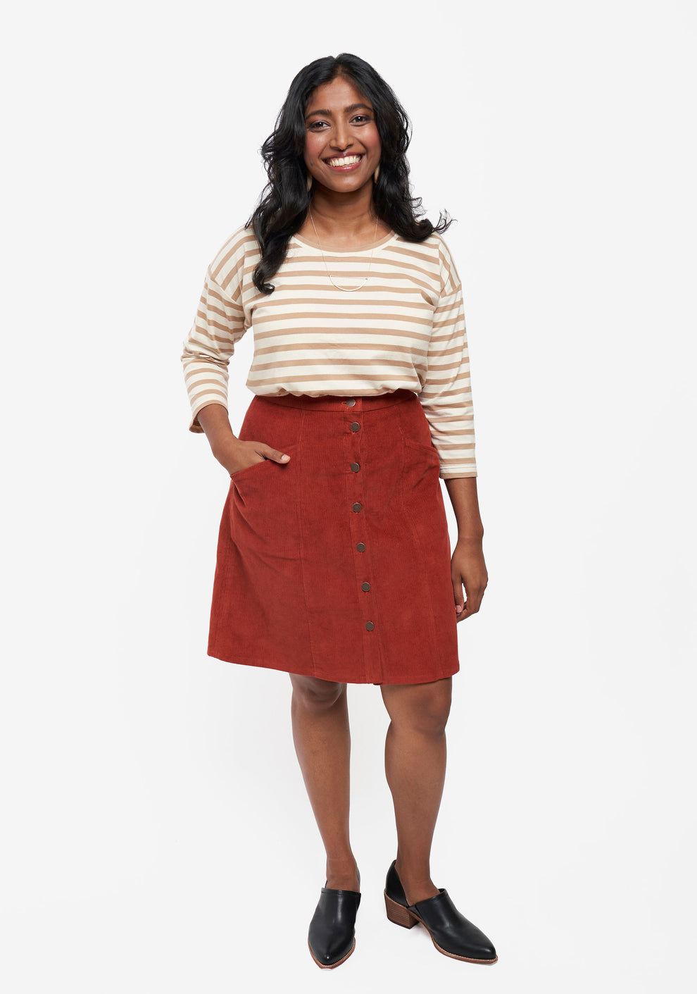 Model: Size 8, 5'5" | Front view of Reed Skirt in rust corduroy with button front and patch pockets, worn by model.