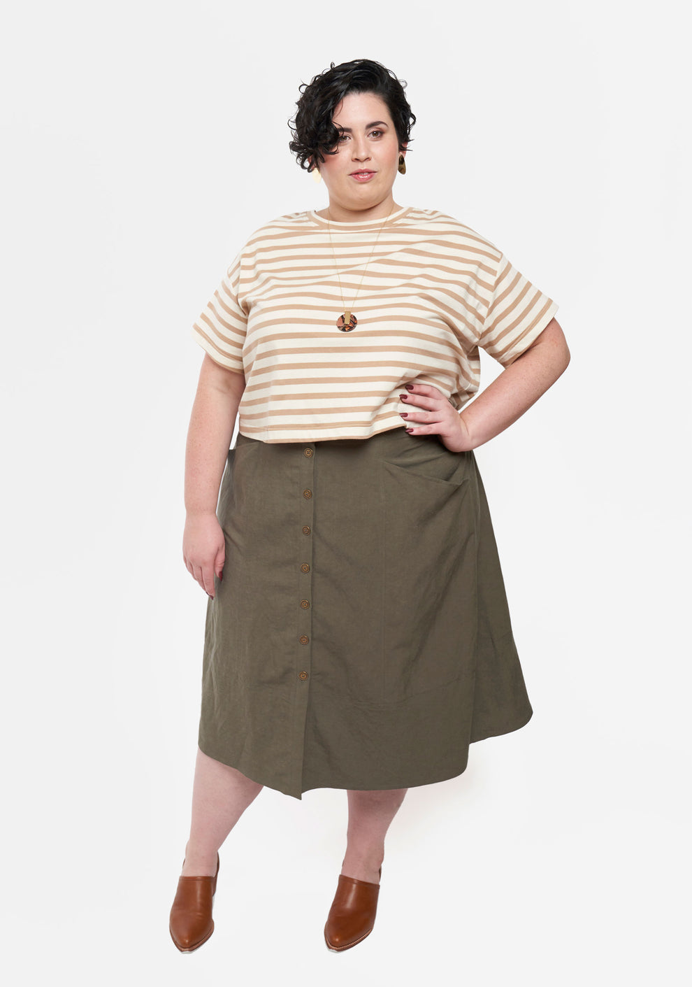 Front view of Reed Skirt in olive fabric with button front and angled pockets.