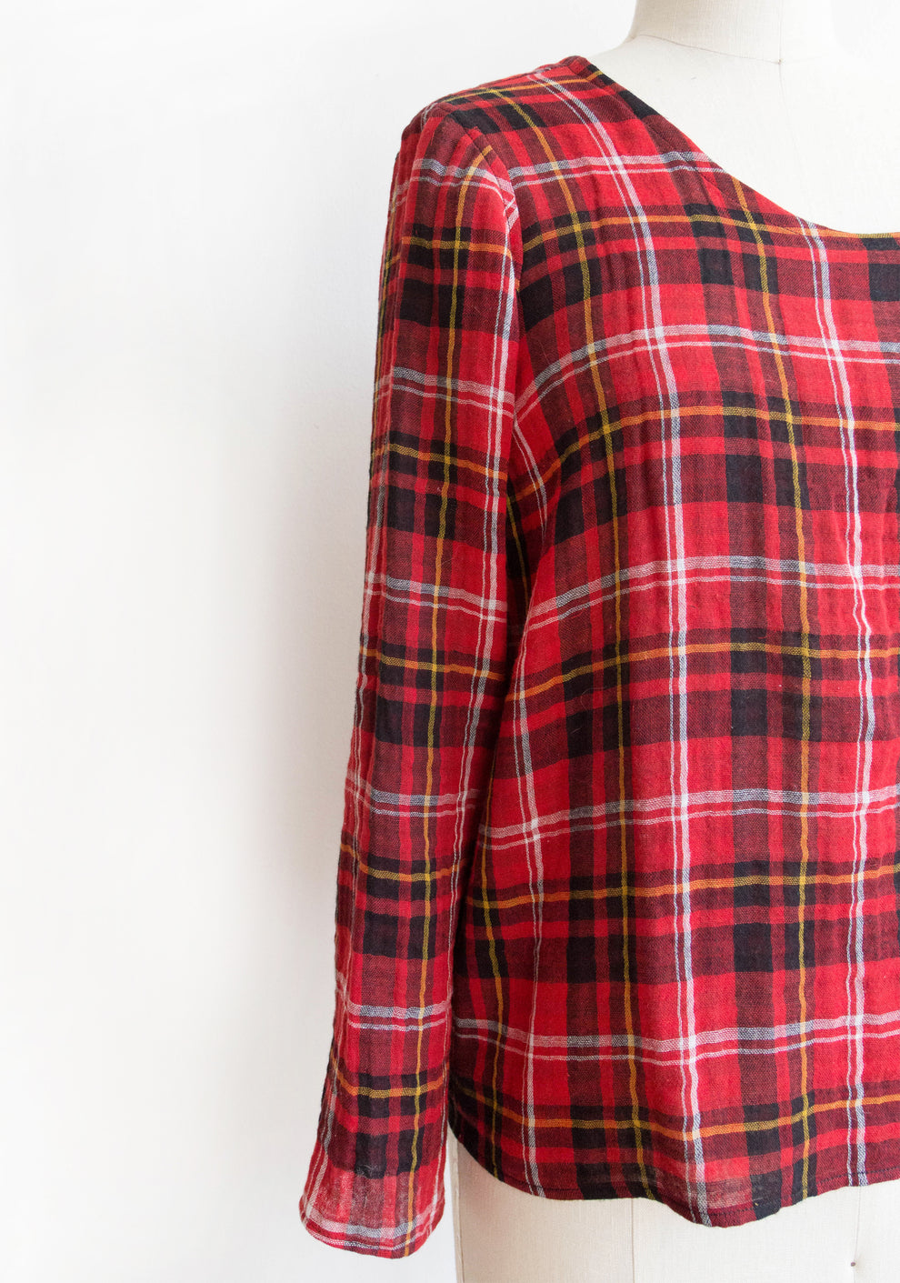 Close-up of Scout Tee long sleeve add-on in red plaid on dress form.