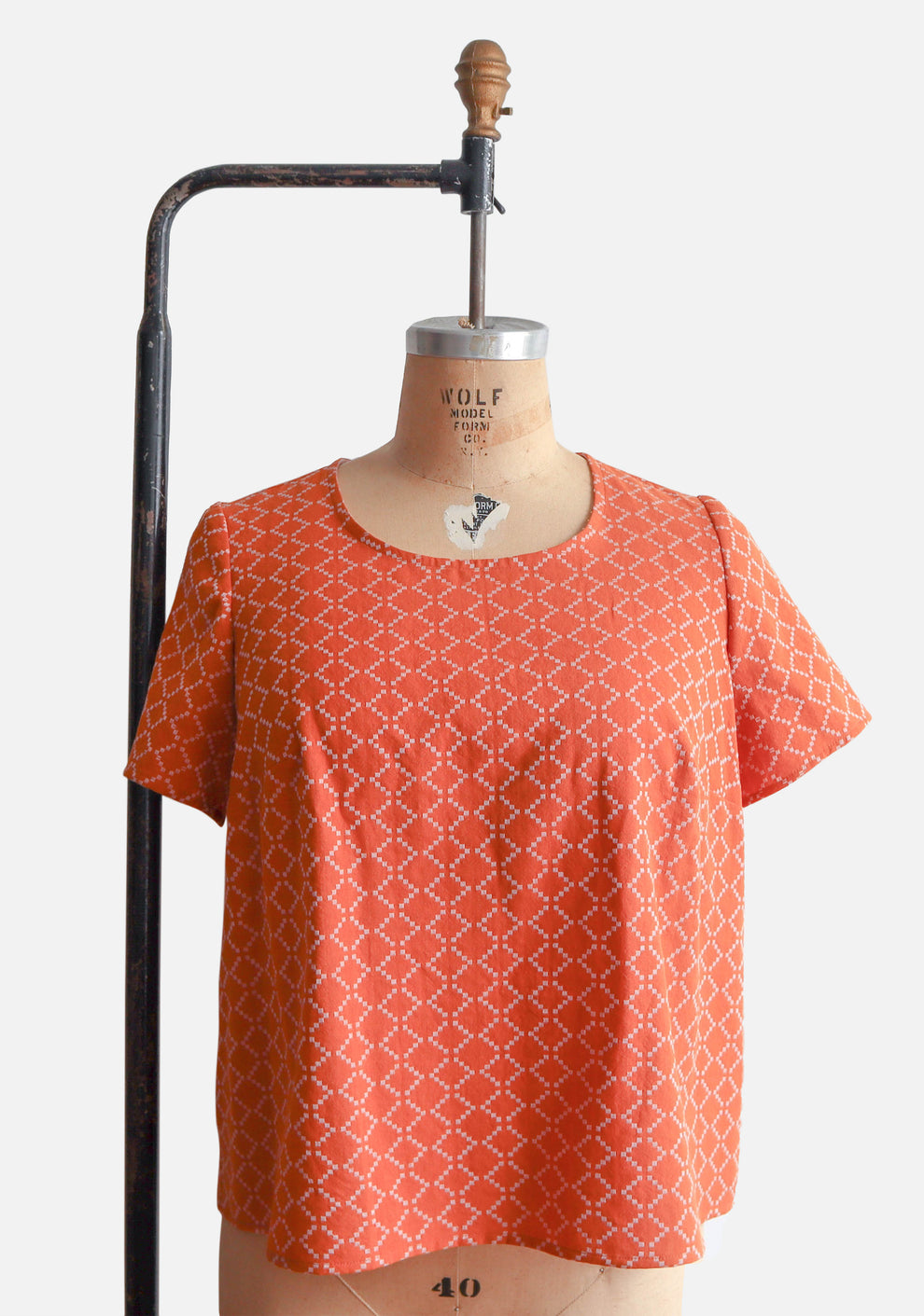 Scout Tee with cuffed sleeves in orange geometric print, displayed on dress form.