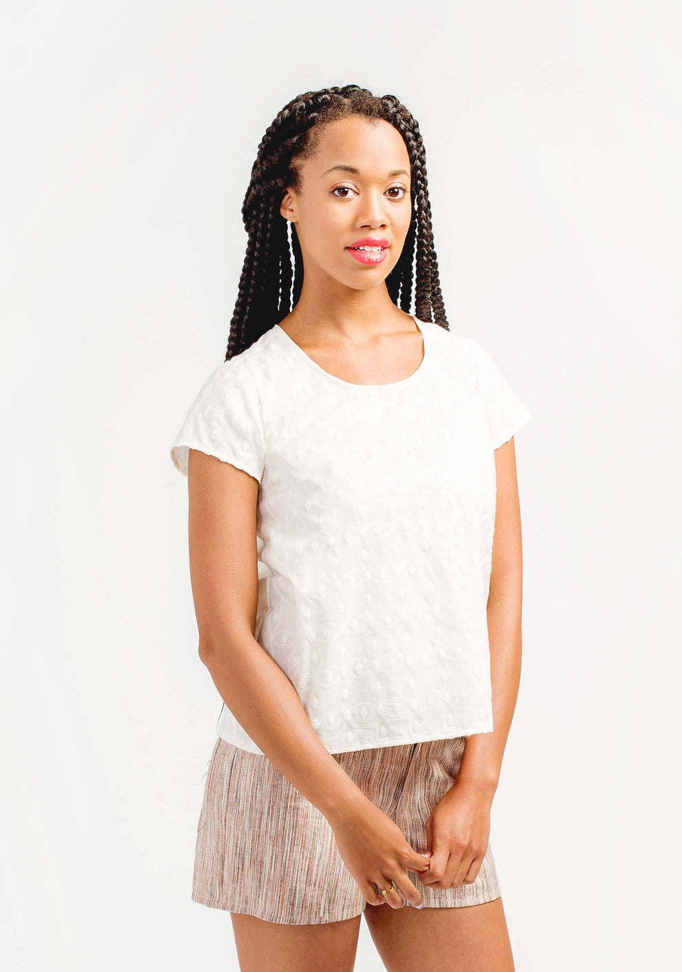 Model wearing white embroidered Scout Tee facing front at slight angle, arms relaxed.