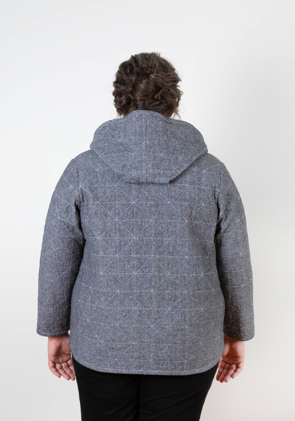 Back view of gray Tamarack Jacket with hood add-on folded down, geometric quilting visible.