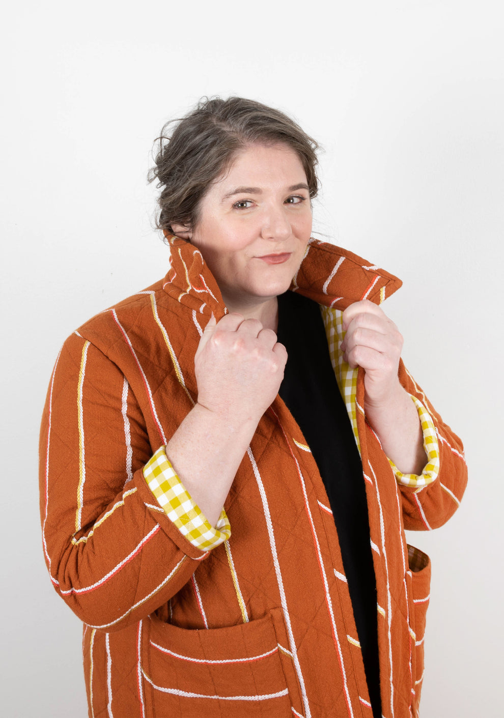 Close-up of model popping collar on orange striped Tamarack Jacket with collar add-on.