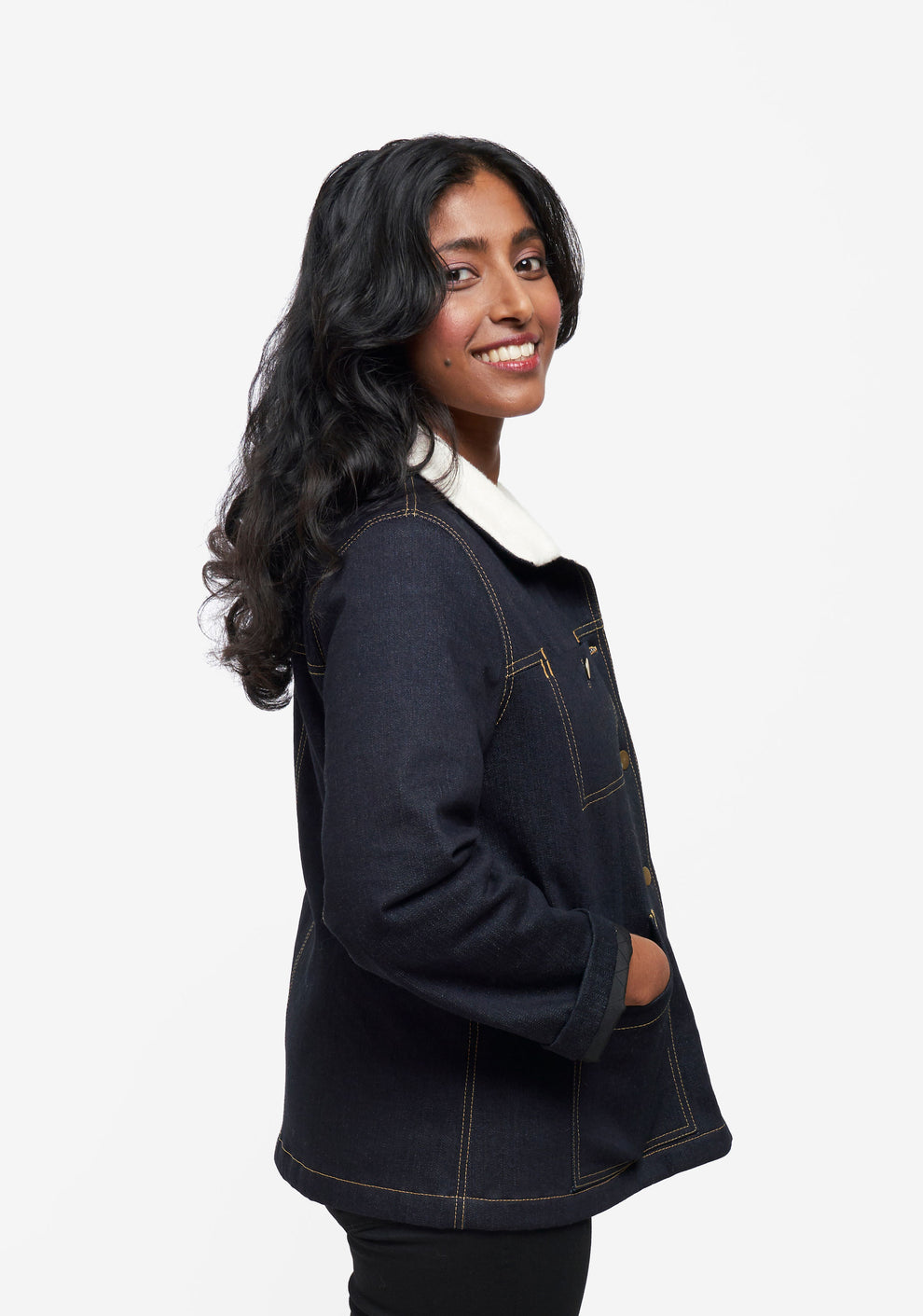 Side view of model wearing Thayer Jacket with hands in pockets.