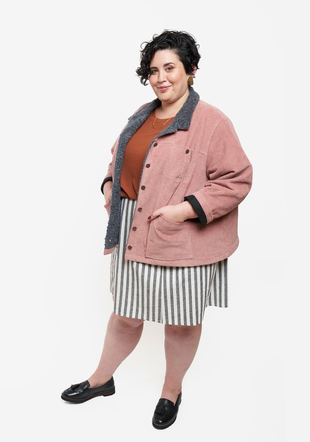 Angled view of model wearing Thayer Jacket styled with striped skirt and rust shirt.