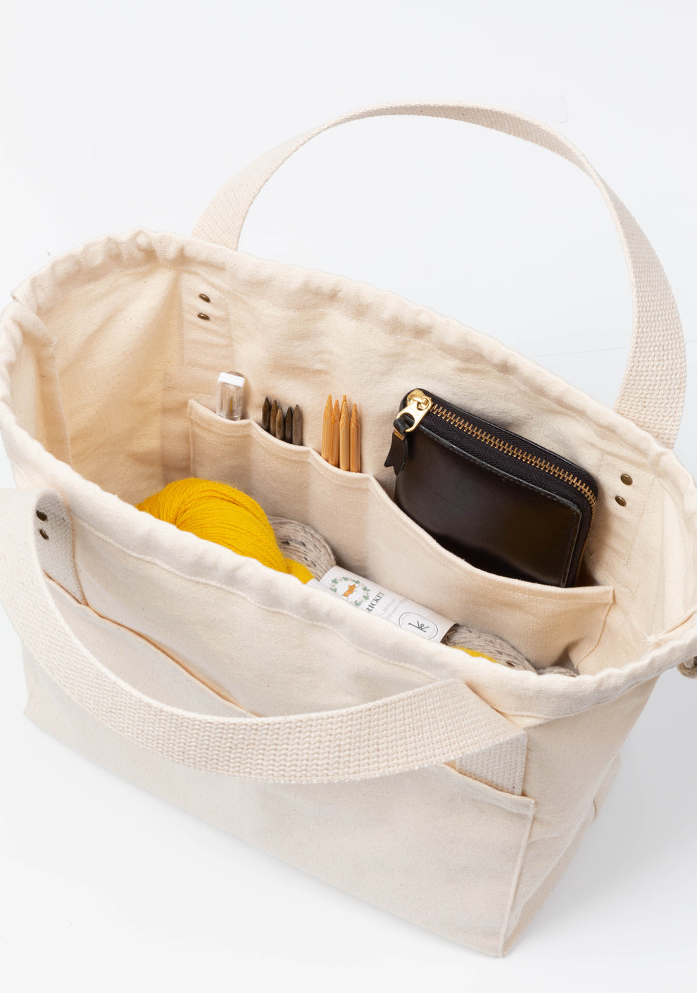 Front view of black canvas Town Bag with white handles and drawstring closure.