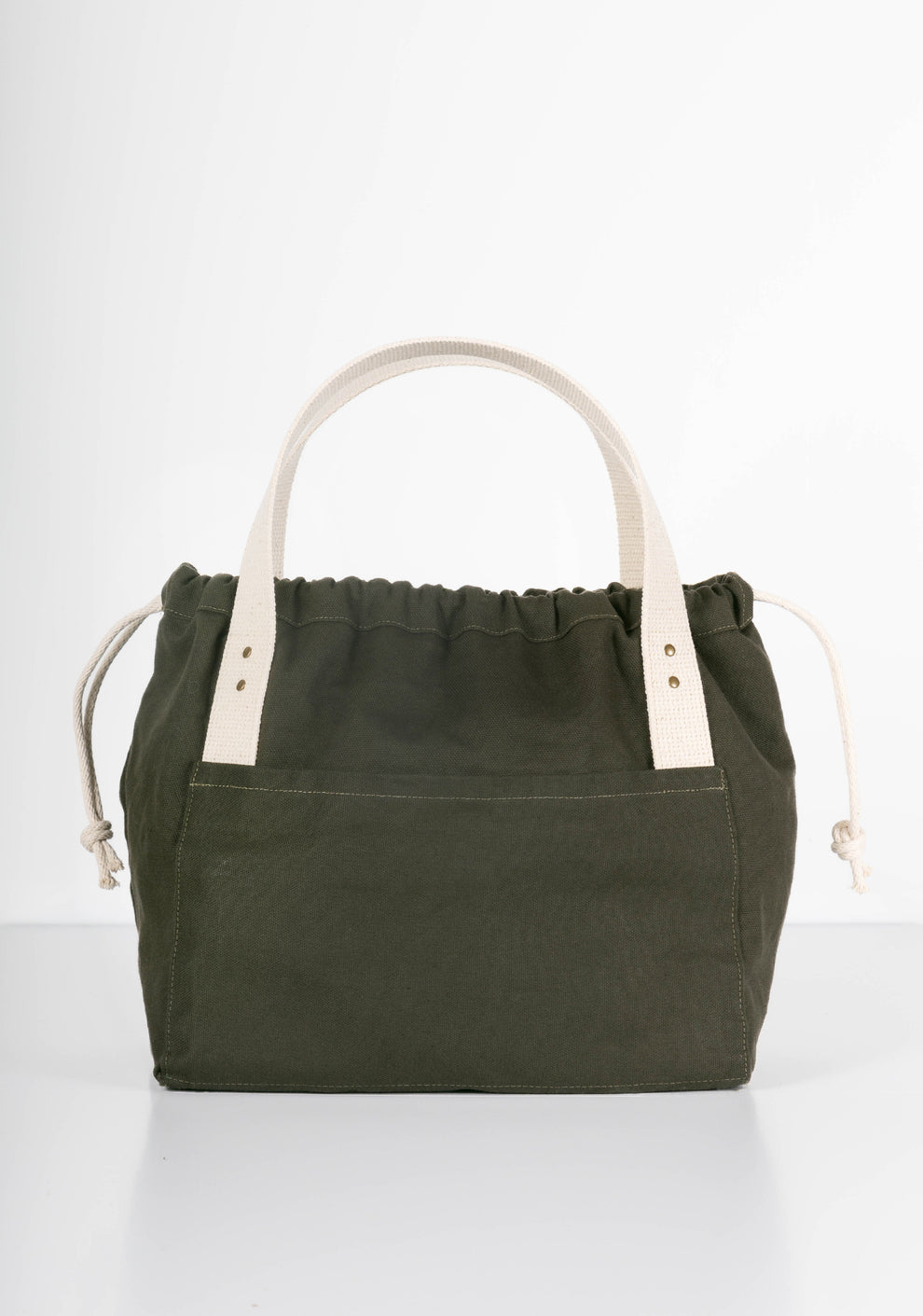 Front view of green canvas Town Bag with white handles and drawstring closed.