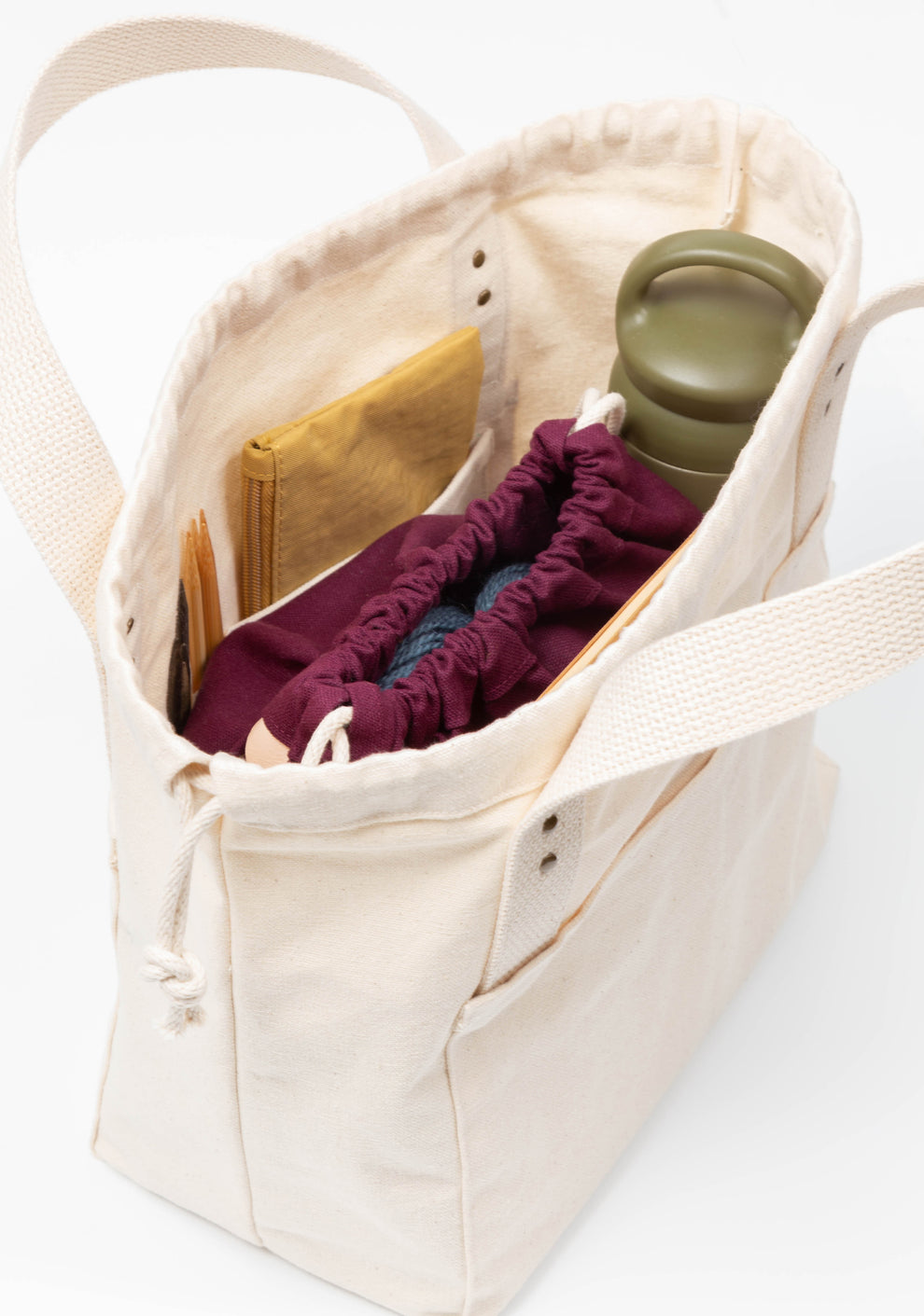 Top angled view of natural Town Bag filled with knitting supplies and accessories.