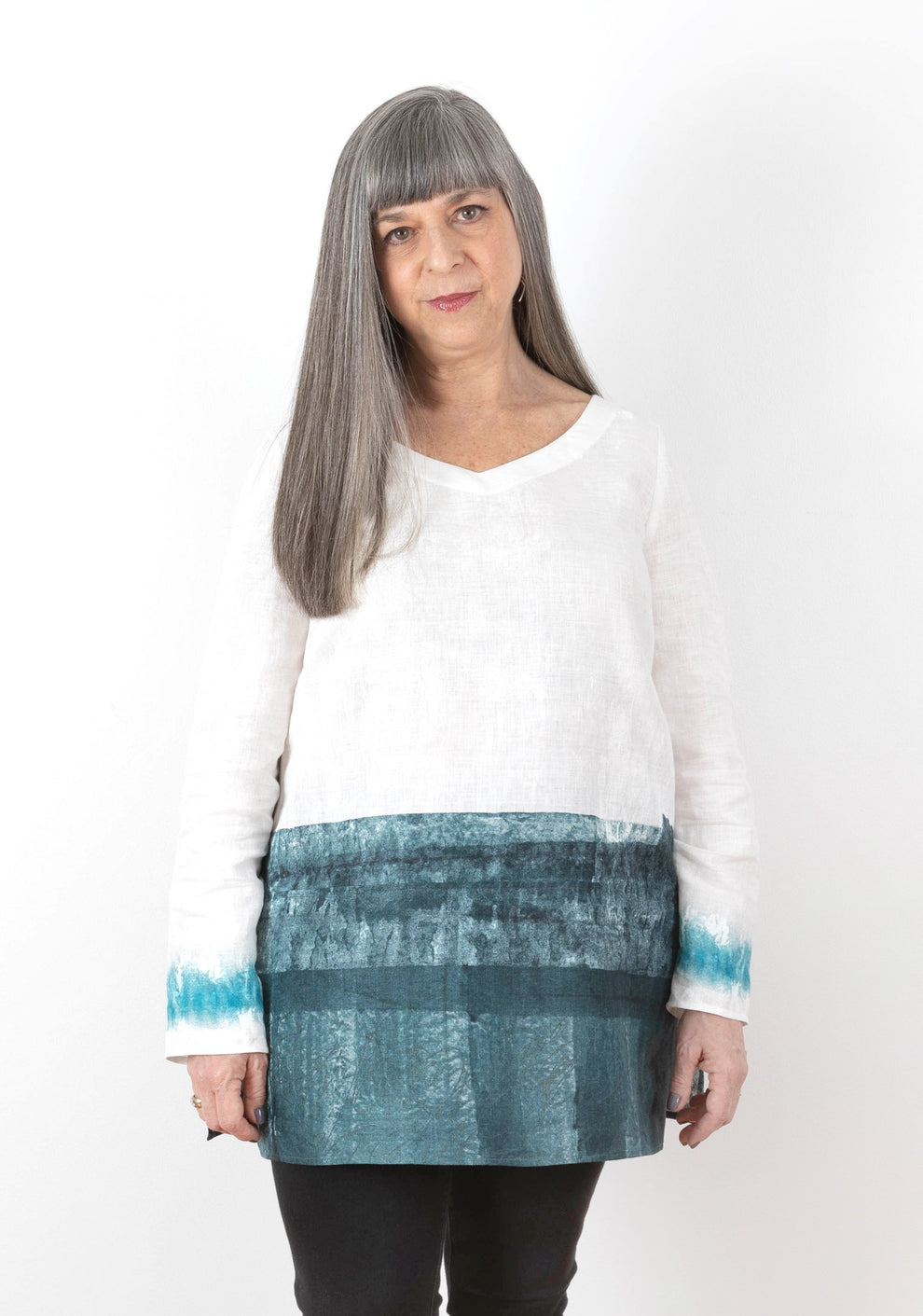 Front view of Uniform Tunic with v-neckline and teal painted lower panel and cuffs on white linen.