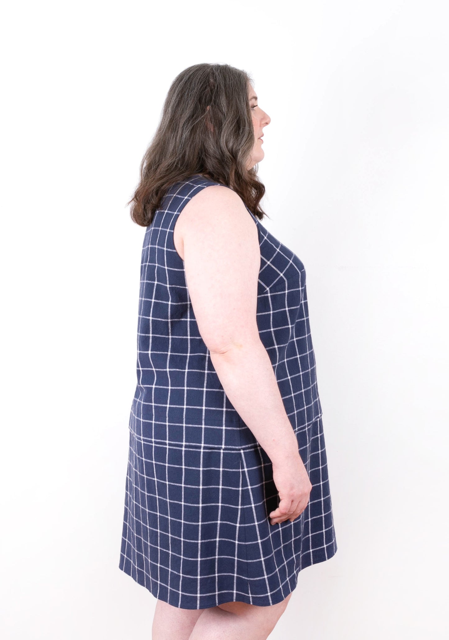 Side view of Willow Dress in navy check fabric showing A-line shape and drop waist seam.