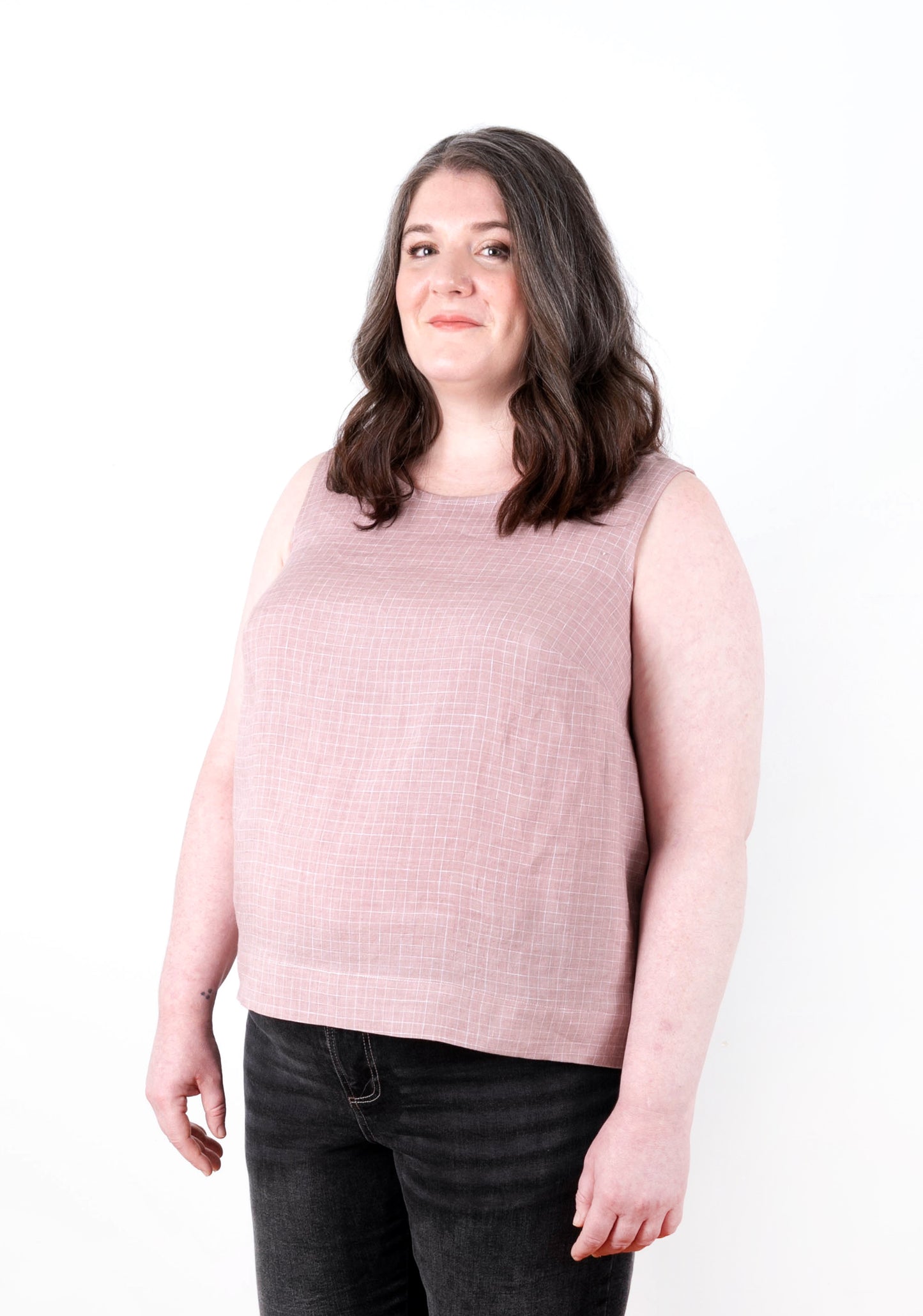 Angled front view of Willow Tank in pink check fabric highlighting simple sleeveless design.