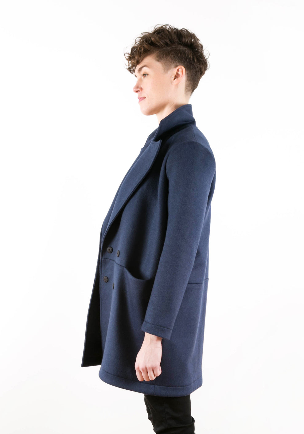 Side view of Yates Coat showing clean side seam and patch pocket on navy wool fabric.